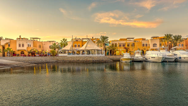 restaurants und motoryachten mit platz zum kopieren vor anker im sonnenuntergang mit orangefarbenem himmel am neuen yachthafen, el gouna, ägypten - scenics building exterior tourist resort orange stock-fotos und bilder