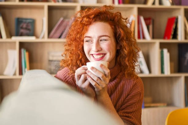 istock Woman sitting on sofa with mug of coffee 1208666476