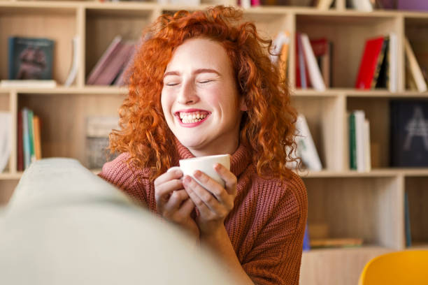 istock Woman sitting on sofa with mug of coffee 1208666490