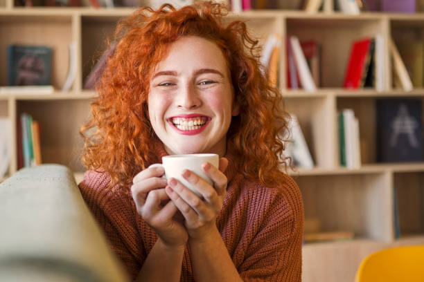 istock Woman sitting on sofa with mug of coffee 1208666620