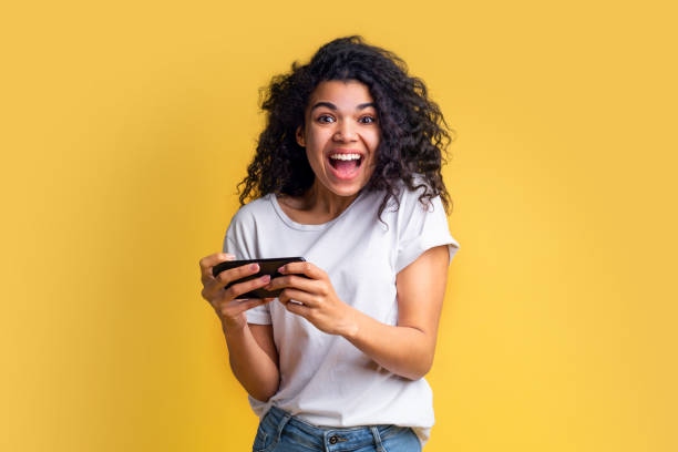 ritratto di attraente giovane afro-americana ragazza utilizzando il telefono cellulare - teenager video game gamer child foto e immagini stock