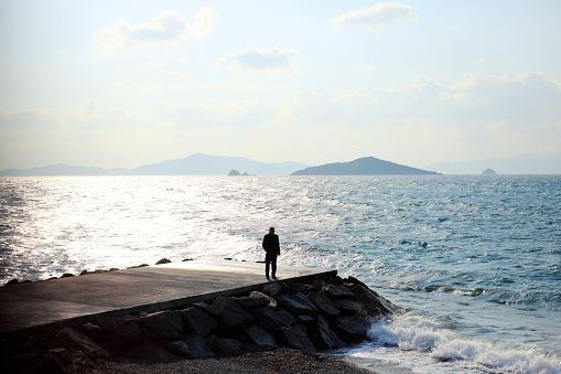 Man on a flysch looking at the Cantabrian Sea on Itzurun beach in Zumaia, Spain. Wanderlust.