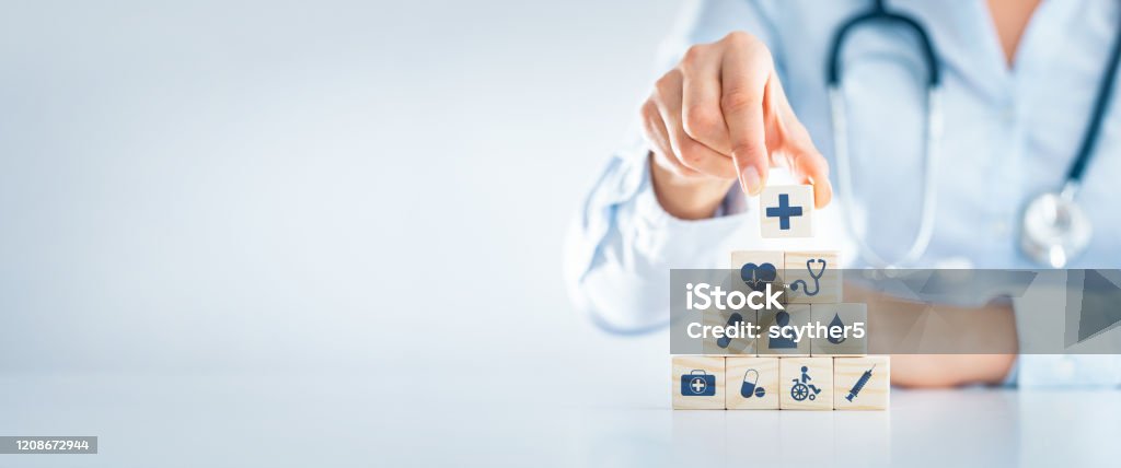 Health insurance - concept. Hand arranging wood block with healthcare medical icon. Health insurance - concept. Healthcare And Medicine Stock Photo