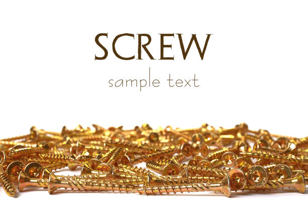 Torx yellow zinc head screws. Gold screws scattered randomly on a white background. soft focus