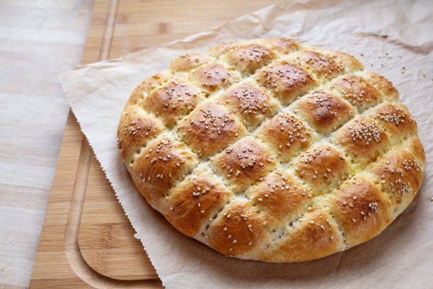 Freshly baked flat bread in the style of turkish ramadan pide on a kitchen board, selected focus, narrow depth of field