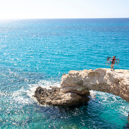 Natural rock bridge above open water; open Mediterranean Sea behind