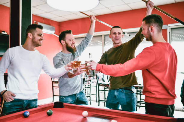 istock Male Friends Enjoying Beer And Pool Game 1208681273