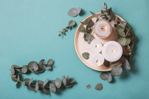 istock eucalyptus leaves and burning candles on blue background 1208683317