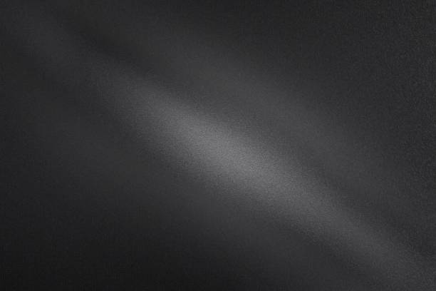 Photo of Light shining through on black dirt metal wall in dark room, abstract texture background