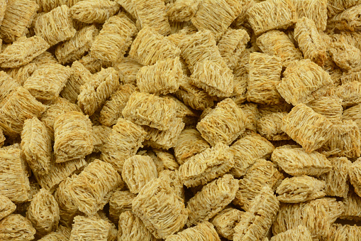 Background from close up of dry shredded whole wheat cereal squares