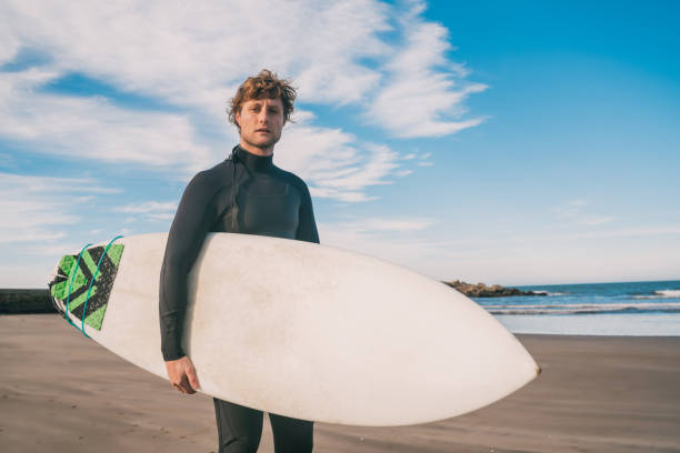 istock Surfer standing in the ocean with his surfboard. 1208694895