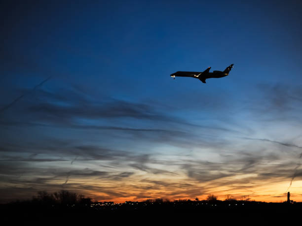 istock Low flying plane silhouetted against beautiful red orange skyline. 1208696535