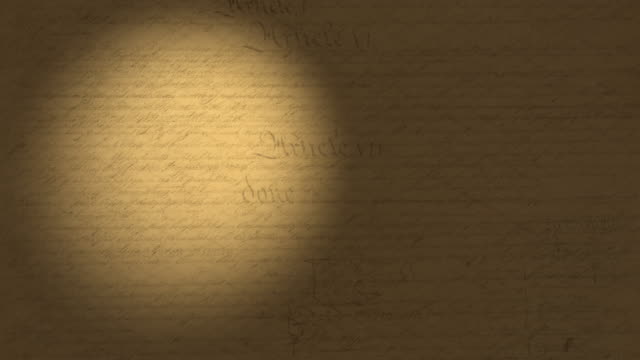 High resolution 4K video of a beam of light moving on the US Constitution pages.