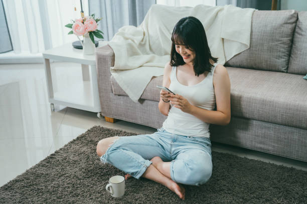 istock charming girl texting on mobile phone online. 1208701306