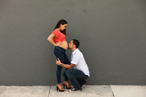 Young pregnant couple lifestyle portrait in a urban setting.