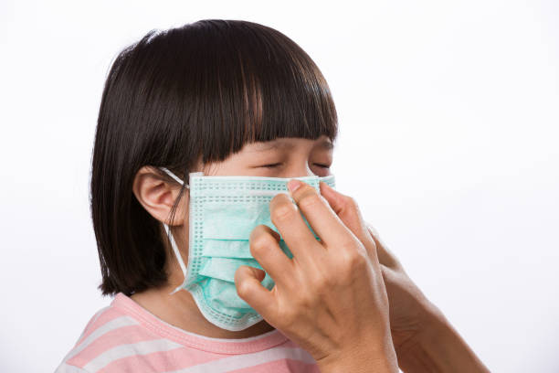 niña asiática usando máscara preventiva de coronavirus - toms fotografías e imágenes de stock