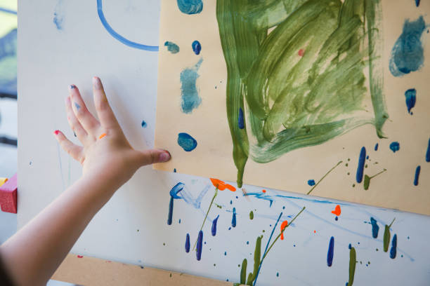 istock Child finger painting on paper 1208706563