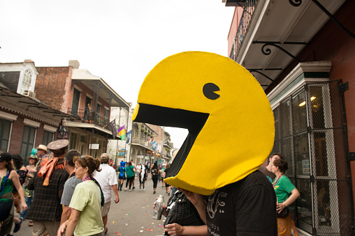In New Orleans, United States a man wearing a large Pac Man head on the street during Mardi Gras in the French Quarter.
