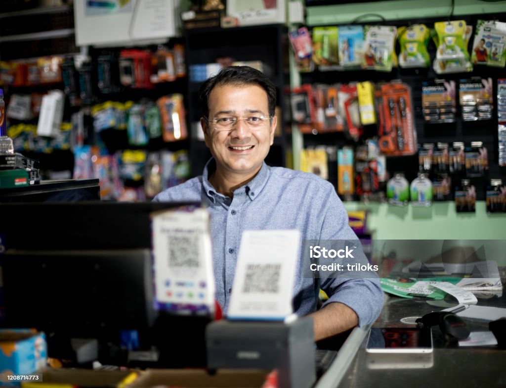 Happy male cashier at supermarket India Stock Photo