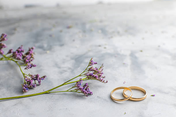 istock two wedding rings on a gray background, flowers. Concept love, wedding 1208715509