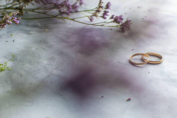 istock two wedding rings on a gray background, flowers. Concept love, wedding 1208715511