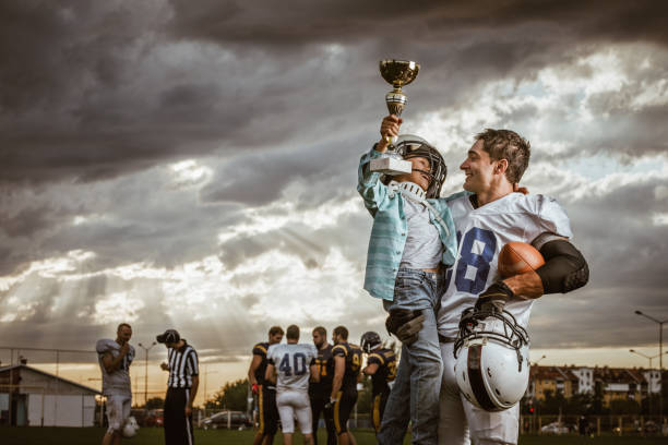 istock Yaaay, my daddy won a trophy in American football game! 1208736324