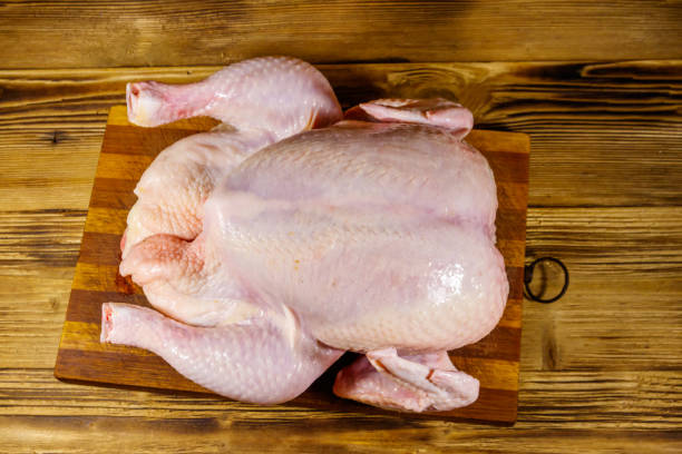 istock Raw whole chicken on a wooden table. Top view 1208736332