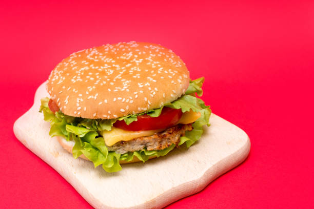 istock one burger on a wooden board on red background with a copy space 1208737974