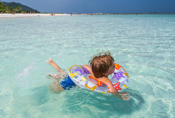 istock Little kid swimming in the sea with inflatable ring. 1208738039