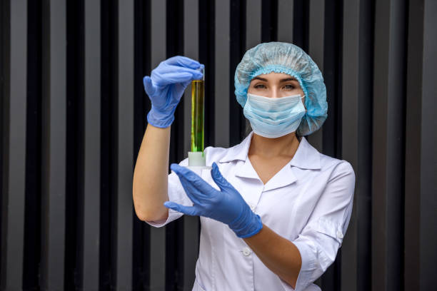istock Chemist holding flask with liquid substance on abstract background 1208738047