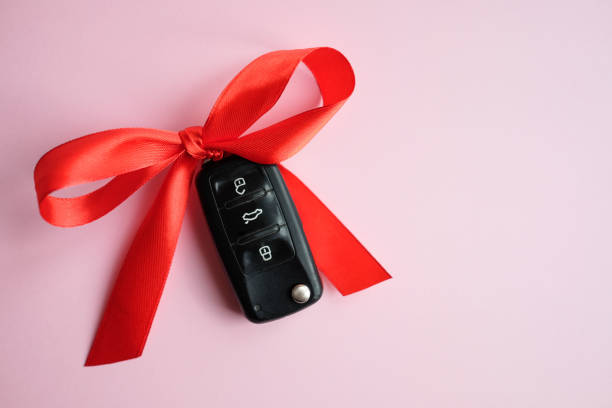 istock Gift car key concept with red bow on a pink background. 1208738962