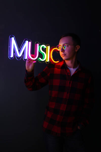 istock Hipster handsome man by neon signs. Multicolored neon sign music. 1208744964