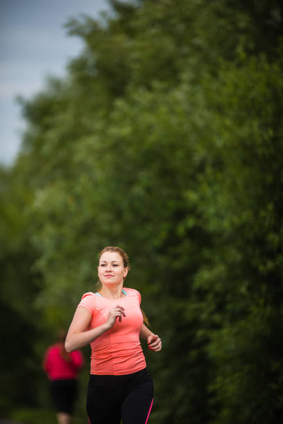 istock Young woman running outdoors on a lovely sunny winter/fall day 1208747516
