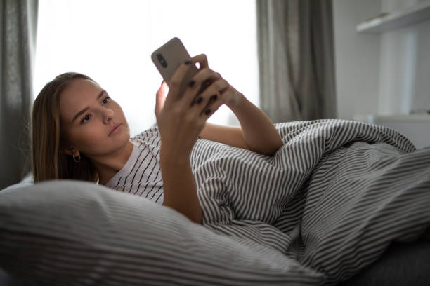 istock Pretty, young woman sleeping in her bed with her cell phone 1208747548