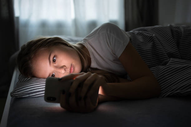 istock Pretty, young woman sleeping in her bed with her cell phone 1208747556
