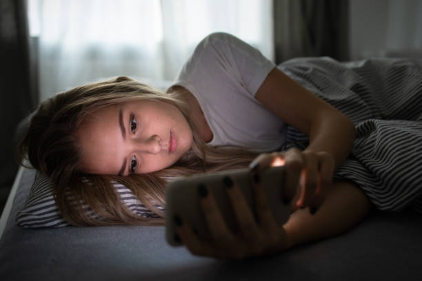 istock Pretty, young woman sleeping in her bed with her cell phone 1208749736