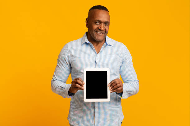 istock Smiling middle aged african man showing blank digital tablet 1208750605
