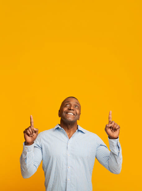 istock Positive african middle aged man pointing up at free space 1208750669