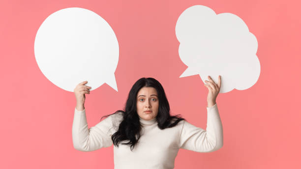 istock Puzzled Obese Girl Holding Two Empty Speech Bubbles Above Her Head 1208752138