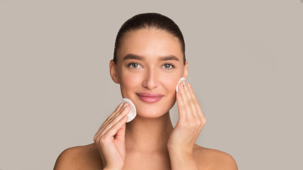 istock Face care. Girl using cotton pad over grey background 1208754173