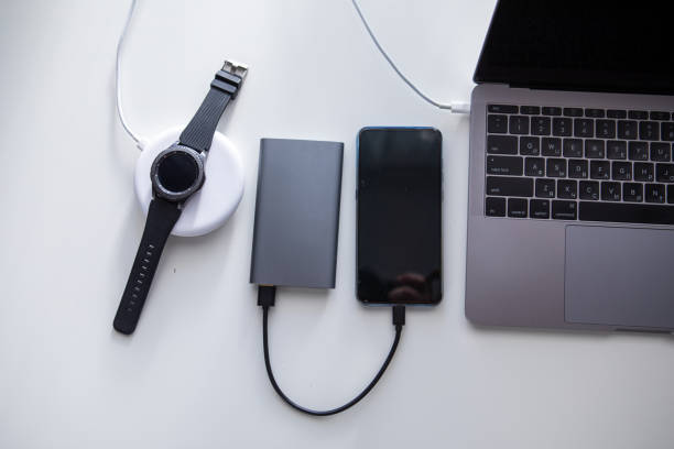 laptop with phone computer mouse and smart watch charging on wireless charger