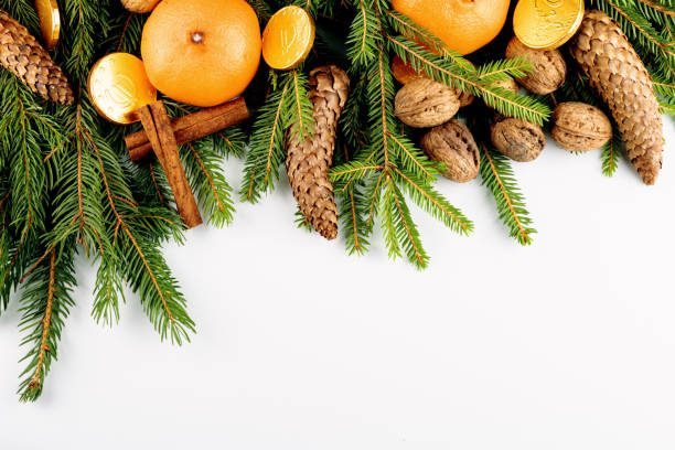 istock Christmas frame made with twigs, cones, walnuts, cinnamon and citrus isolated on white 1208756020