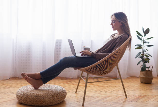 istock Young woman browsing on laptop, relaxing with coffee 1208757479