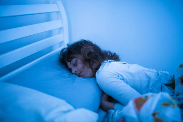 istock Small 11 year old girl sleeping in bed on a stomach. 1208757858