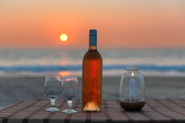 Beach party at sunset Sunset at beach cafe with rose wine, glass and candle on a tropical beach in GOA, India goa beach party stock pictures, royalty-free photos & images