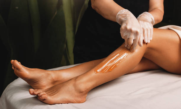 fotografii de stoc, fotografii și imagini scutite de redevențe cu tanara caucaziana care are proceduri de epilare cu zahar la salonul spa - epilare cu ceară