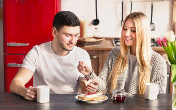 istock Woman helping her husband to spread jam on sandwich 1208759880