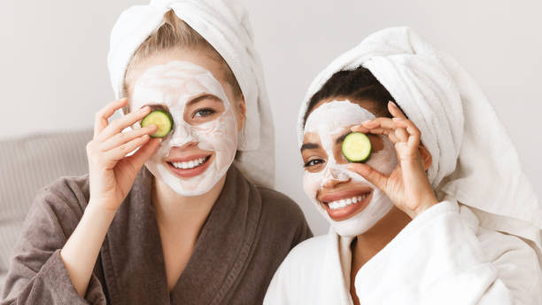 istock Panoramic photo of smiling girlfriends making face care procedures 1208759954