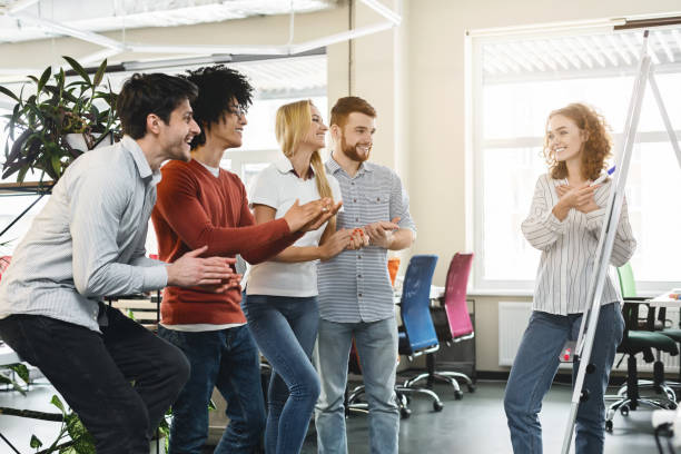 istock Positive team cheering female colleague making presentation 1208760225