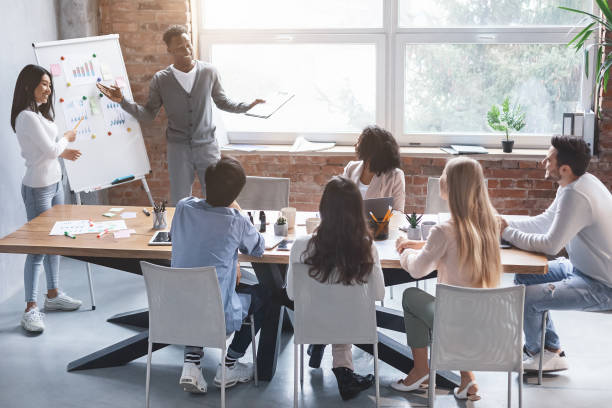 istock Black guy and asian girl making presentation at office 1208760453